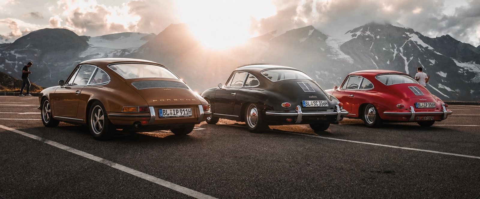 Three classic Porsches at sunset in the Alps
